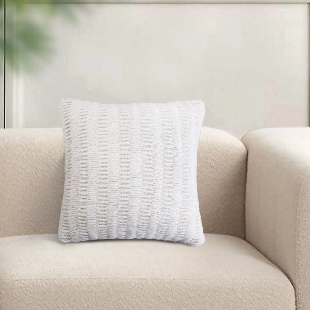 Cuscino Renaud bianco ambientato su un divano moderno dal design minimalista in un salotto luminoso.