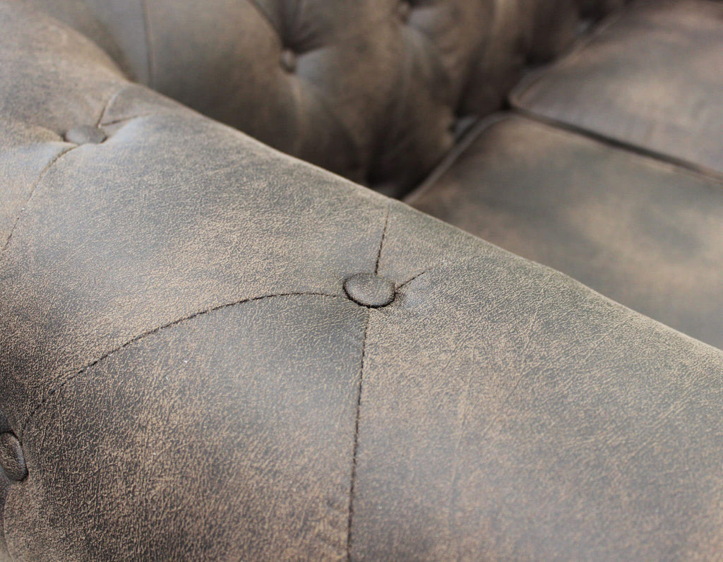 Primo piano dei braccioli del divano Chesterfield, che evidenzia l'effetto vintage