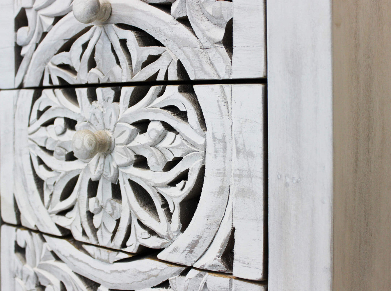 Primo piano dei cassetti intarsiati del Mobile Foster che mostra la venatura del legno di mango e il decoro sbiancato.