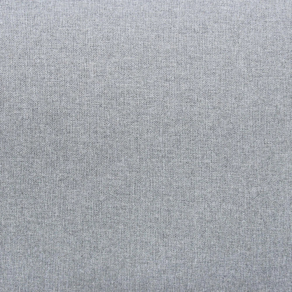 Dettaglio colore del cuscino del Set salotto da esterno Madeira 2P in alluminio verniciato antracite con cuscini grigi, composto da divano a due posti, due poltrone e un tavolino, ambientato in un patio con ghiaia bianca e parete in pietra.