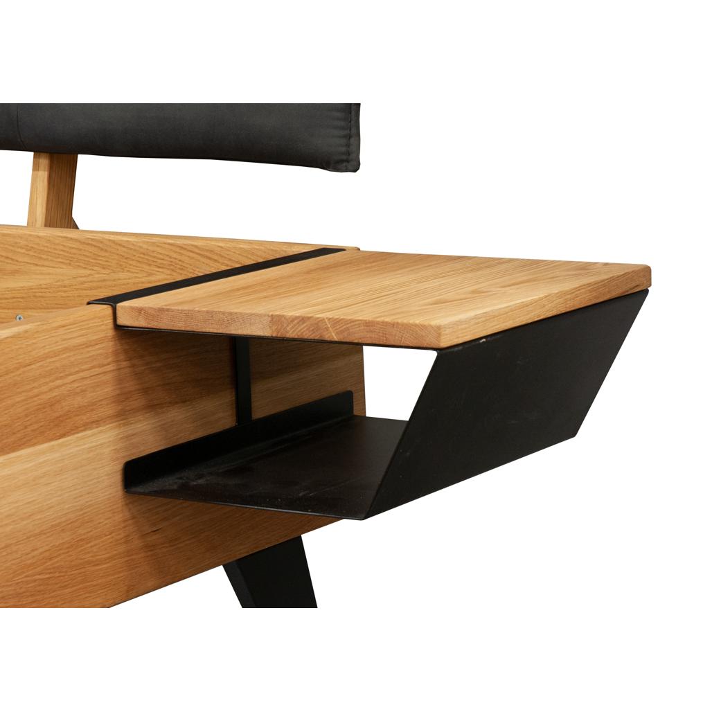 Primo piano del dettaglio della mensola in metallo nero integrata nel comodino Kana, evidenziando la finitura e la fusione con il legno di rovere | Albert Stock