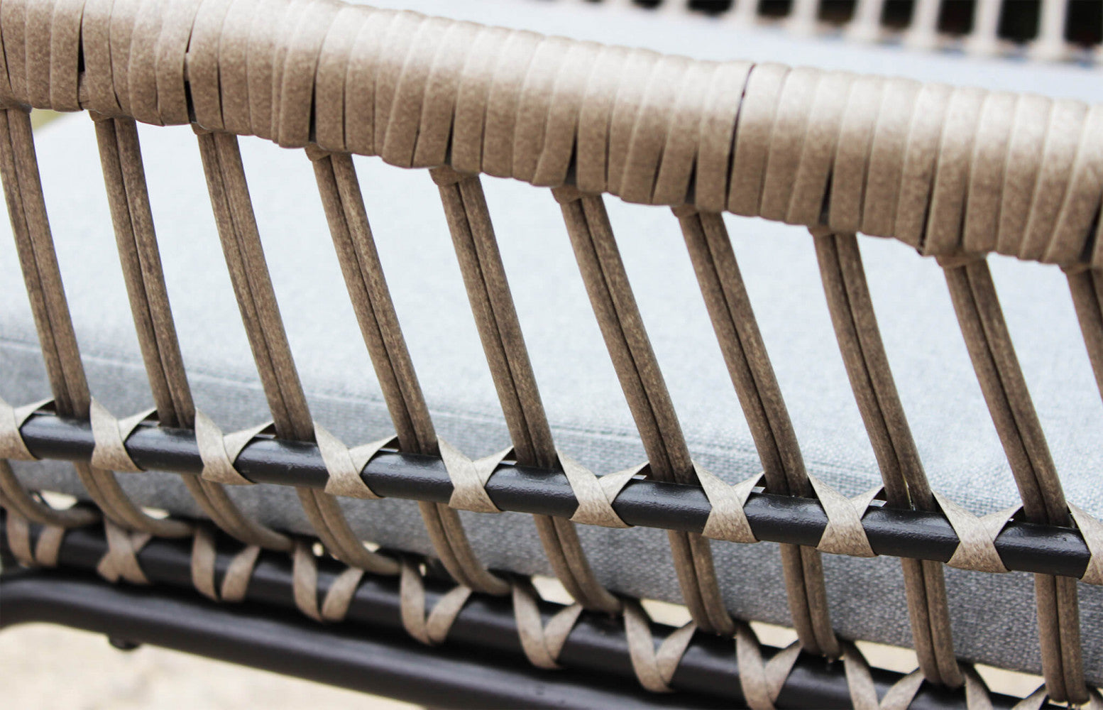 Primo piano della struttura in metallo grigio scuro e intreccio di una poltrona del salotto Mombasa, che evidenzia la finitura e il design pulito