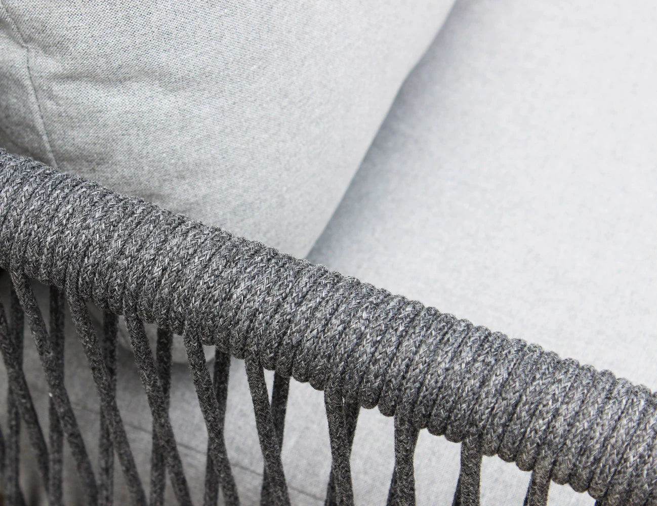 Dettaglio Intreccio del Set salotto da esterno Madeira 2P in alluminio verniciato antracite con cuscini grigi, composto da divano a due posti, due poltrone e un tavolino, ambientato in un patio con ghiaia bianca e parete in pietra