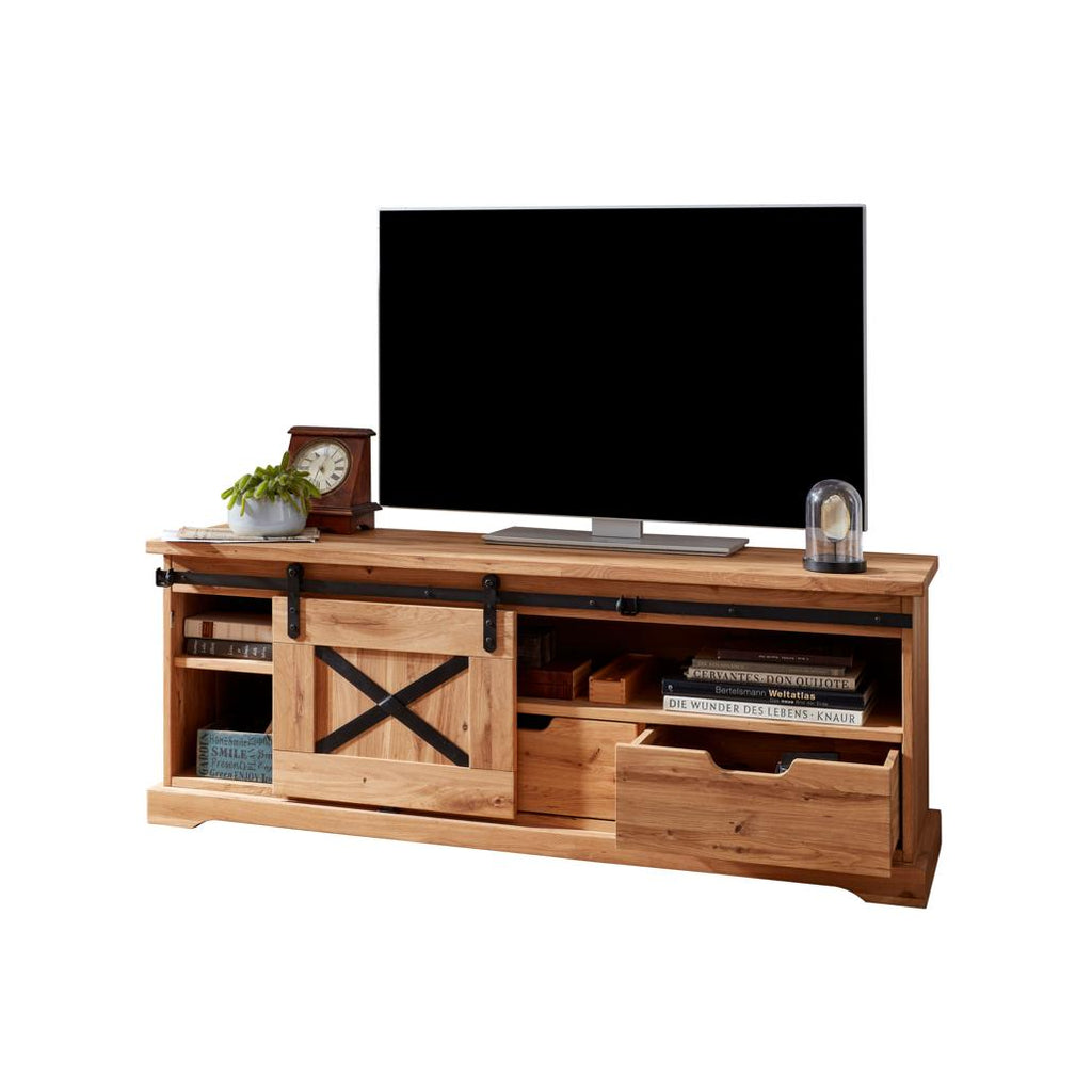 Primo piano del dettaglio del frontale del mobile TV Nyks I, evidenziando il segno metallico a "X" e la venatura del rovere massiccio | Albert Stock