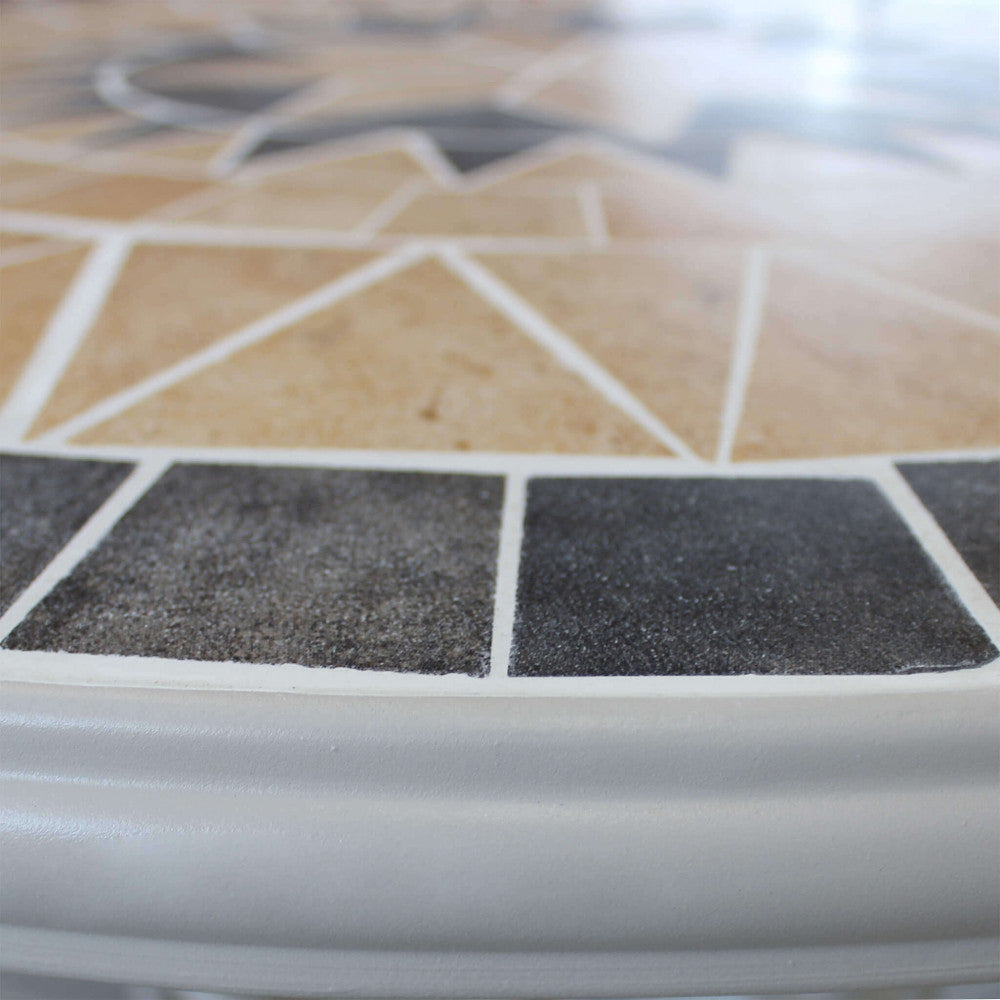 Primo piano del piano del Tavolo Rotondo Perse, mostrando i dettagli del mosaico in cemento marrone chiaro e grigio e la finitura | Albert Stock