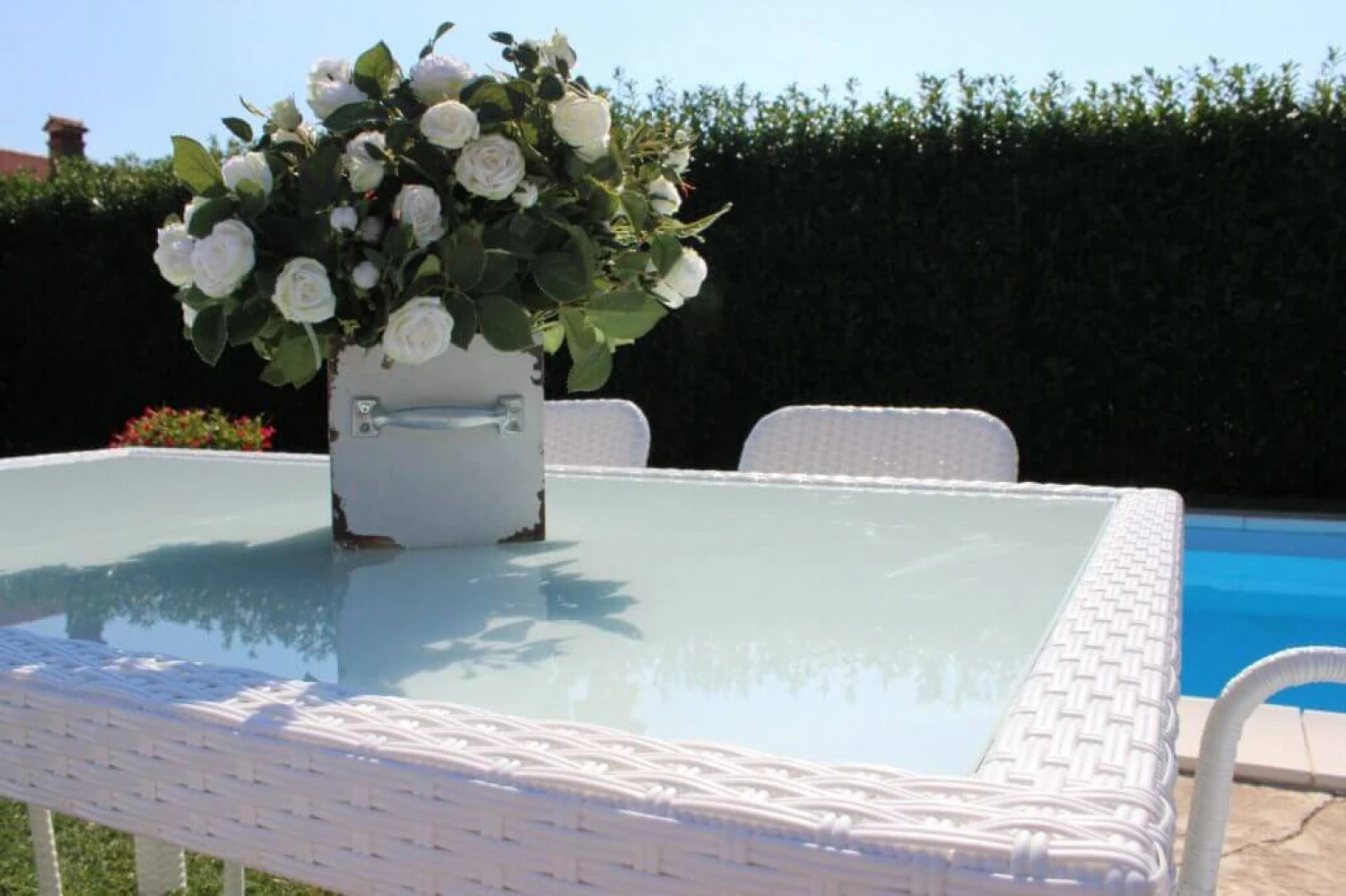 Tavolo da pranzo Azore 150x90 Bianco, struttura in alluminio rivestita in polyrattan e piano in vetro temperato, panoramica ambientazione bordo piscina