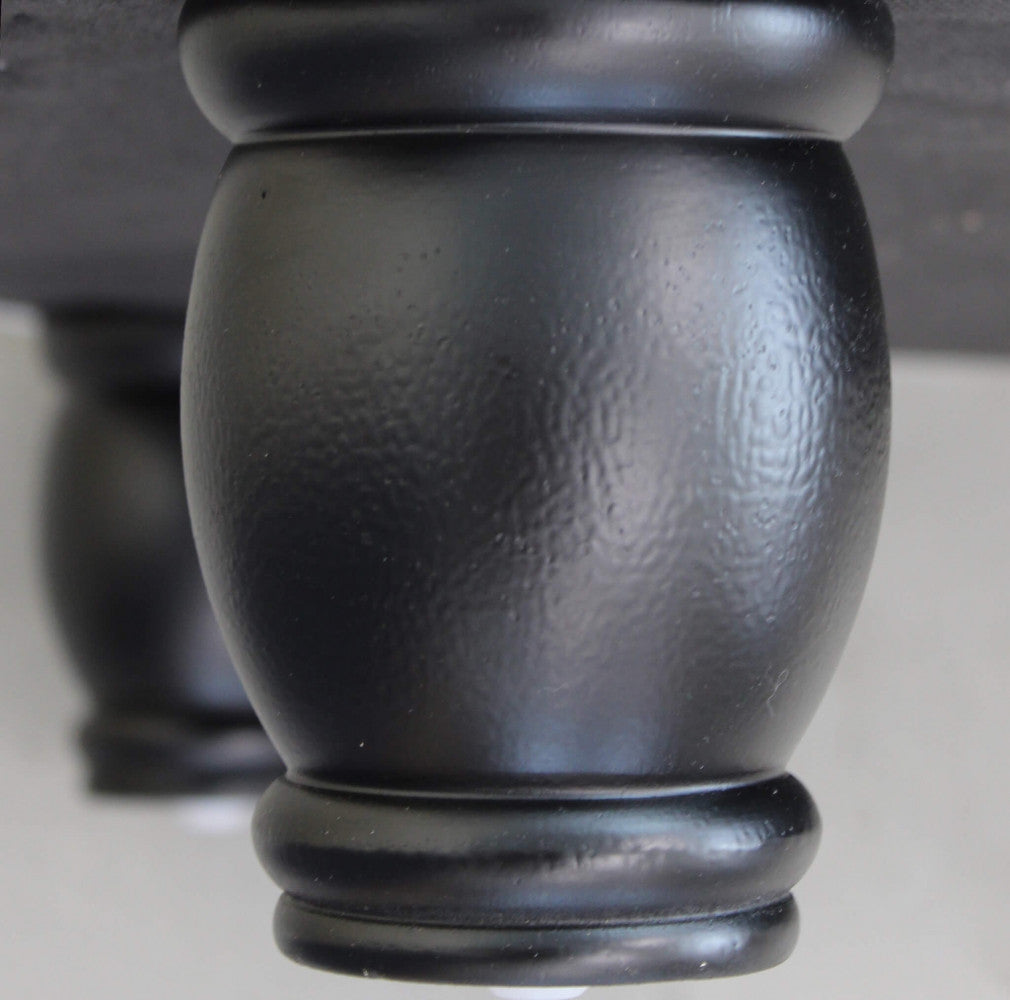 Primo piano dei piedi del divano Chesterfield, che evidenzia la texture e i bottoni.