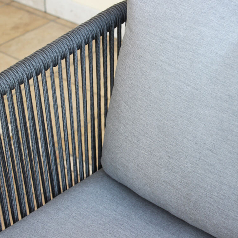 Primo piano del tavolino del salotto Cancun, che mostra il piano in vetro con finitura effetto ceramico e l'intreccio della corda Olifen