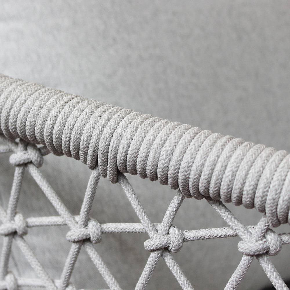 Primo piano della struttura di una poltrona del salotto Seychelles, che evidenzia la lavorazione intrecciata della corda in textilene e la finitura dell'alluminio
