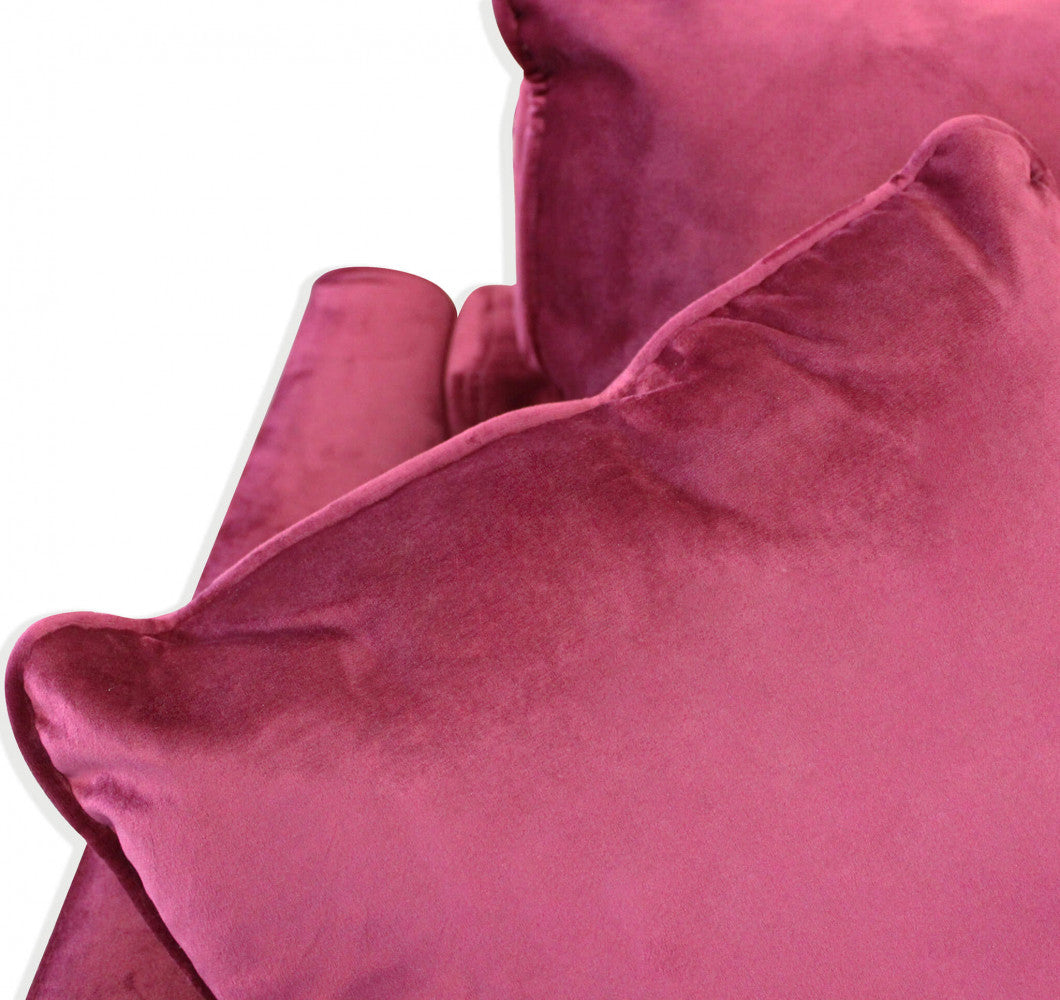 Dettaglio ravvicinato dei cuscini in velluto rosso che mostra la texture morbida e cangiante.