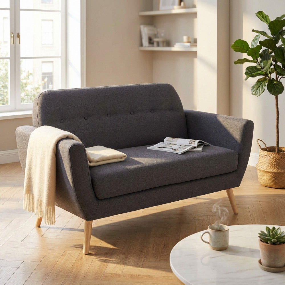 Divano 2 posti Burton in tessuto grigio scuro, ambientato in un luminoso salotto moderno con pavimento in parquet e tavolino in marmo.