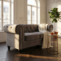 Divano 2 posti Chesterfield in velluto grigio illuminato dalla luce naturale in un salotto classico.