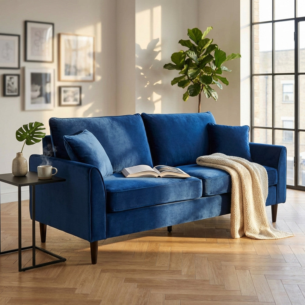 Divano a 3 posti Chandler in velluto blu inserito in un luminoso soggiorno moderno con piante d'appartamento.