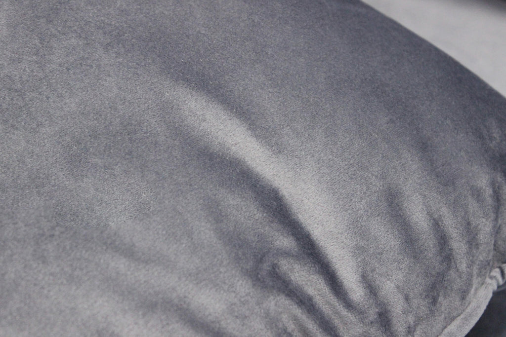 Primo piano della texture in velluto grigio chiaro, che mostra la morbidezza e la reazione alla luce del tessuto.