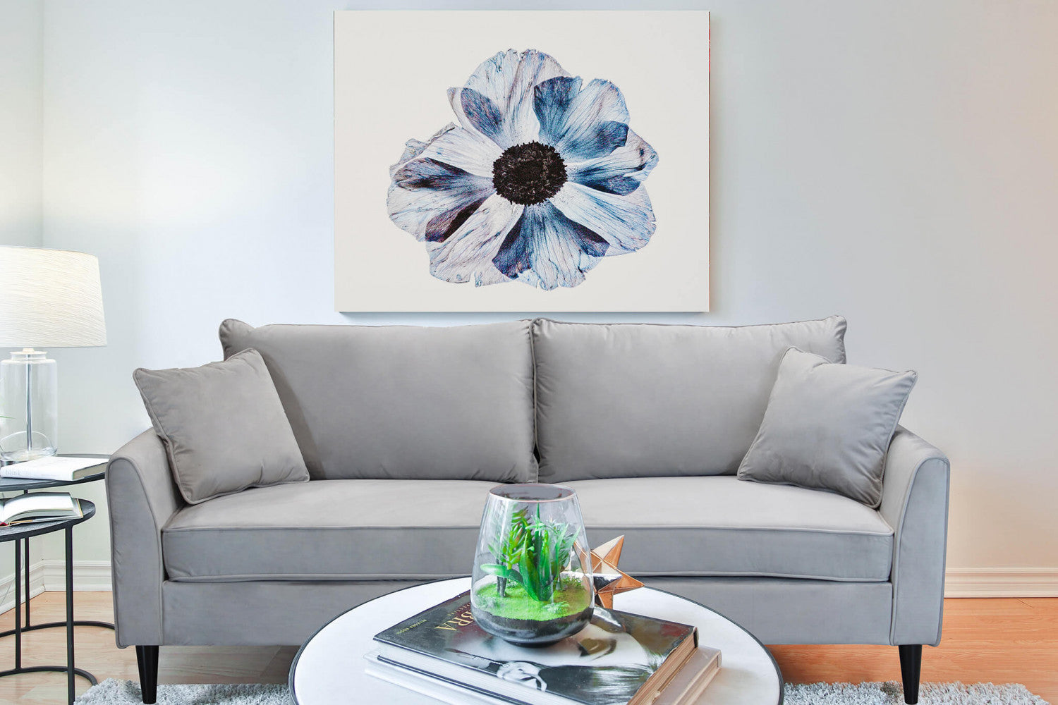 Divano Chandler inserito in un salotto moderno con un grande quadro floreale azzurro sulla parete.