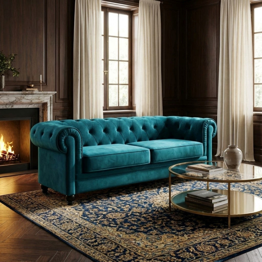 Divano Chesterfield blu inserito in un lussuoso salone classico con boiserie scura, camino acceso e tappeto decorato.