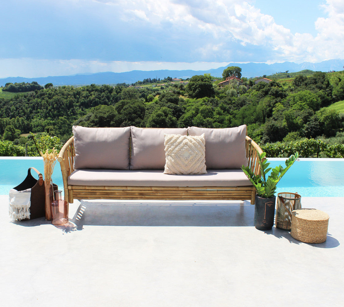 Divano BRONX in legno marrone a bordo piscina con cuscini decorativi e vista panoramica.