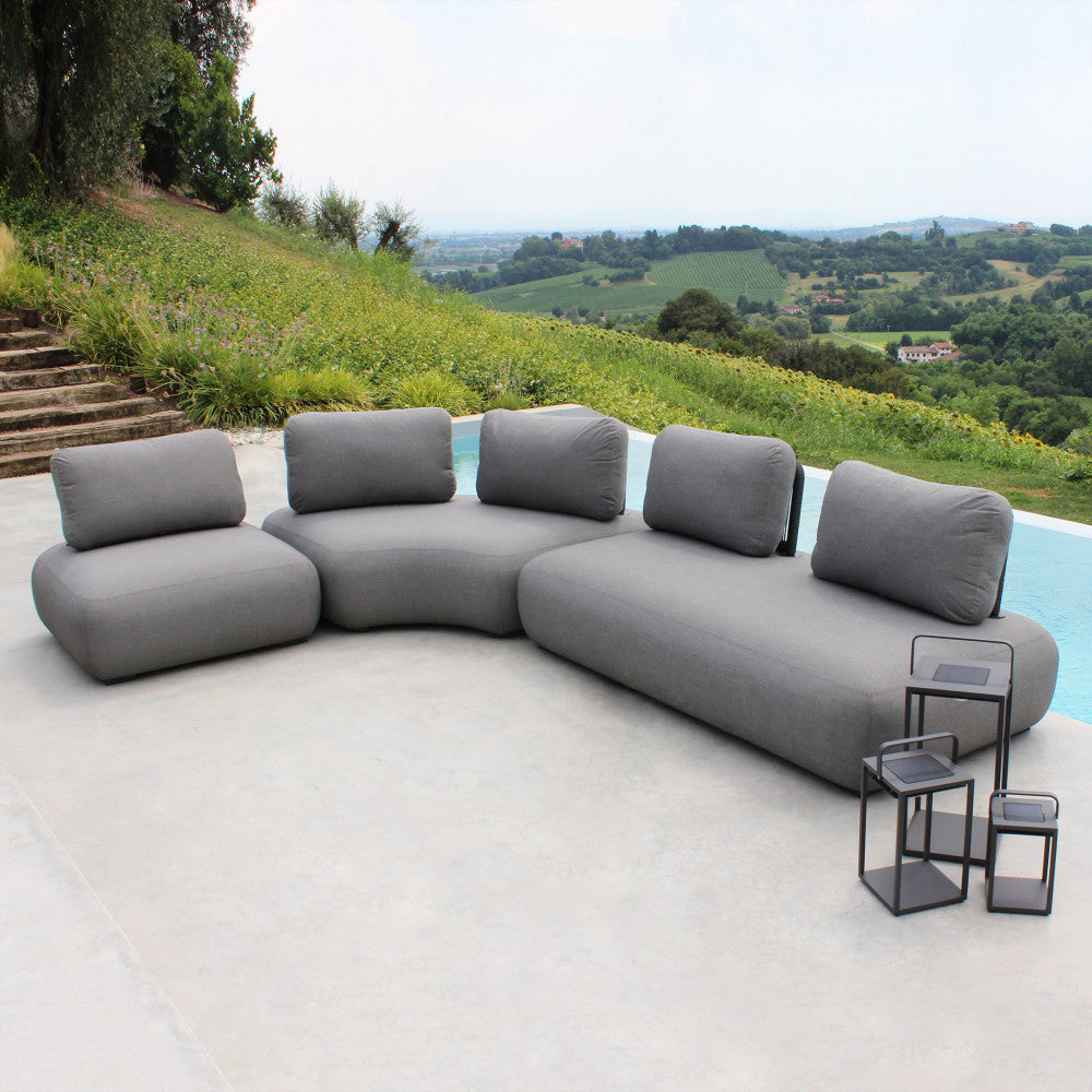 Ampia configurazione curva del salotto modulare Malawi in un lussuoso ambiente outdoor con piscina.