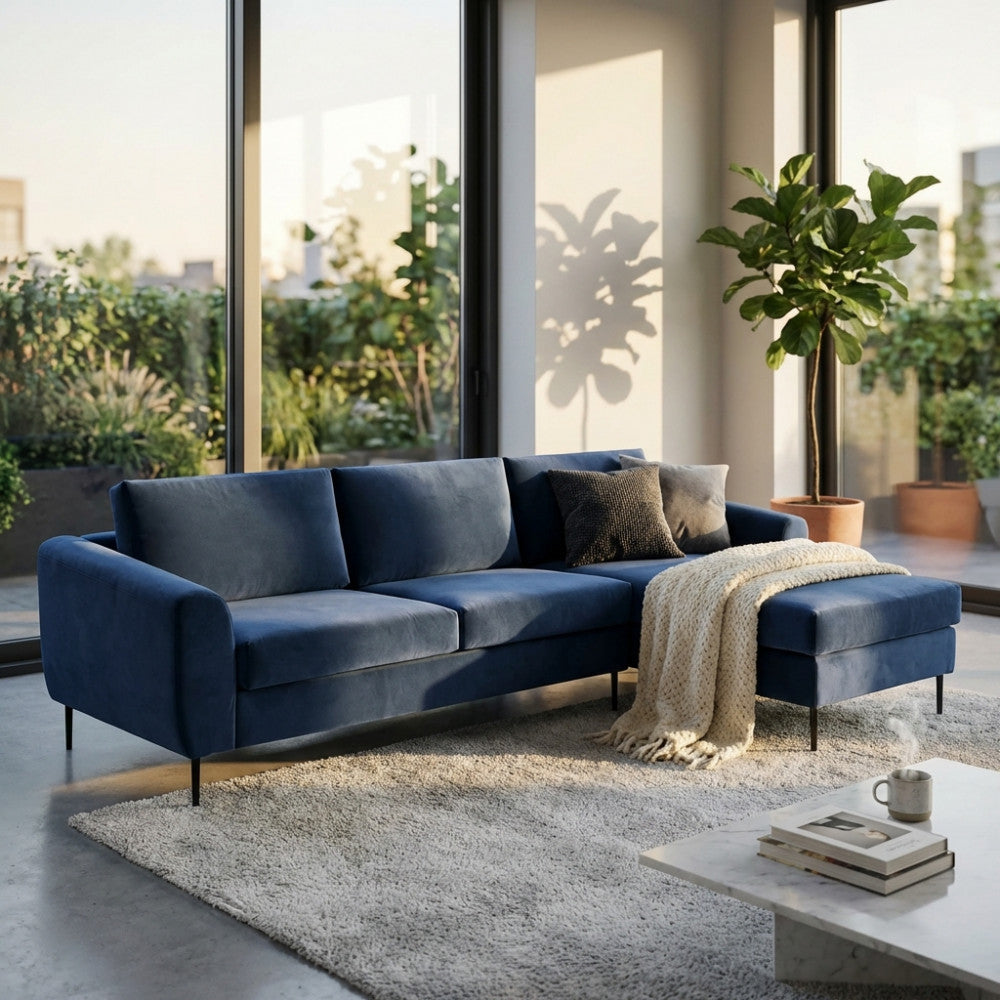 Divano con chaise longue Gregory in tessuto blu, vista frontale in un salotto luminoso.