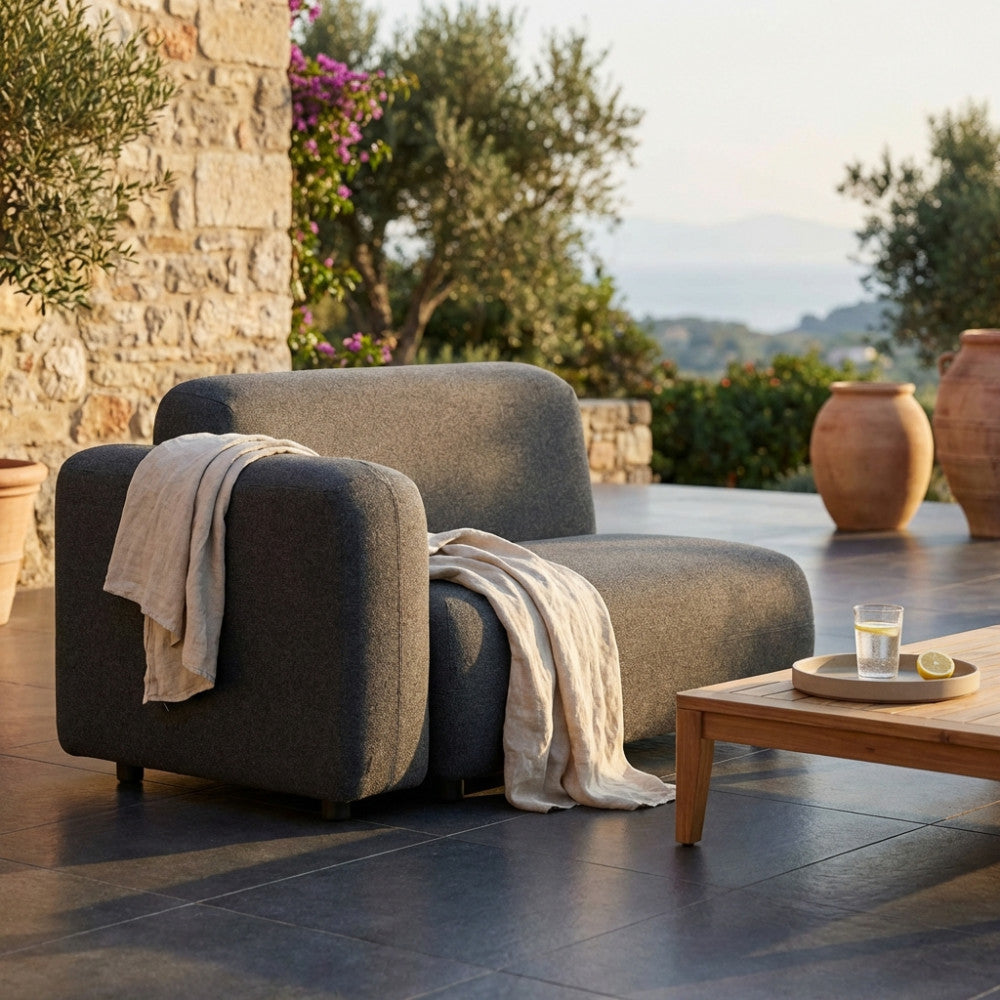 Divano modulare destro Tucumã in alluminio grigio scuro, ambientato in un patio esterno con luce solare calda.