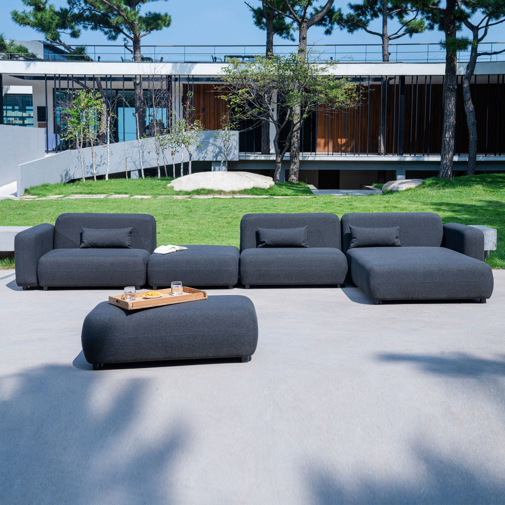 Composizione completa della famiglia di divani modulari Tucumã in un ampio giardino contemporaneo.
