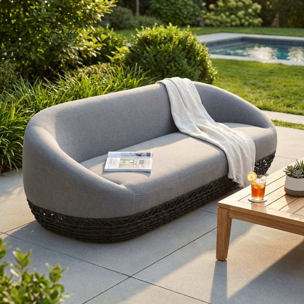 Divano moderno Lafayette a tre posti in corda grigia e alluminio, ambientato in un giardino di lusso a bordo piscina.