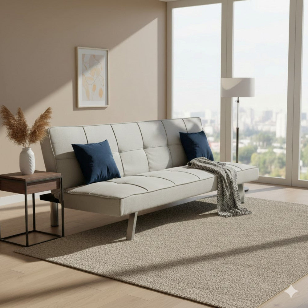 Divano letto Aaron inserito in un ampio living contemporaneo con grandi vetrate, tappeto testurizzato e cuscini blu scuro a contrasto.