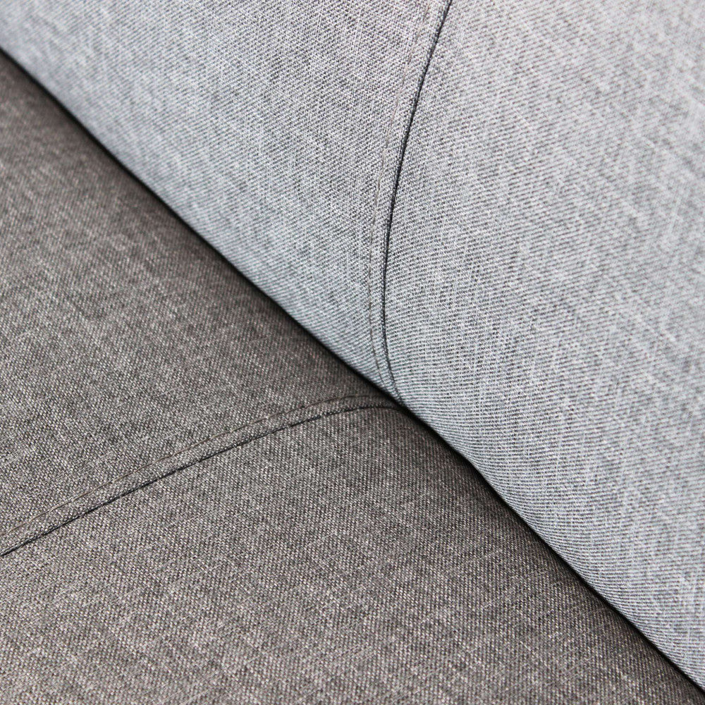 Macro fotografia della trama del tessuto grigio del divano letto Alvin, mostrando la cucitura sartoriale e la texture materica.