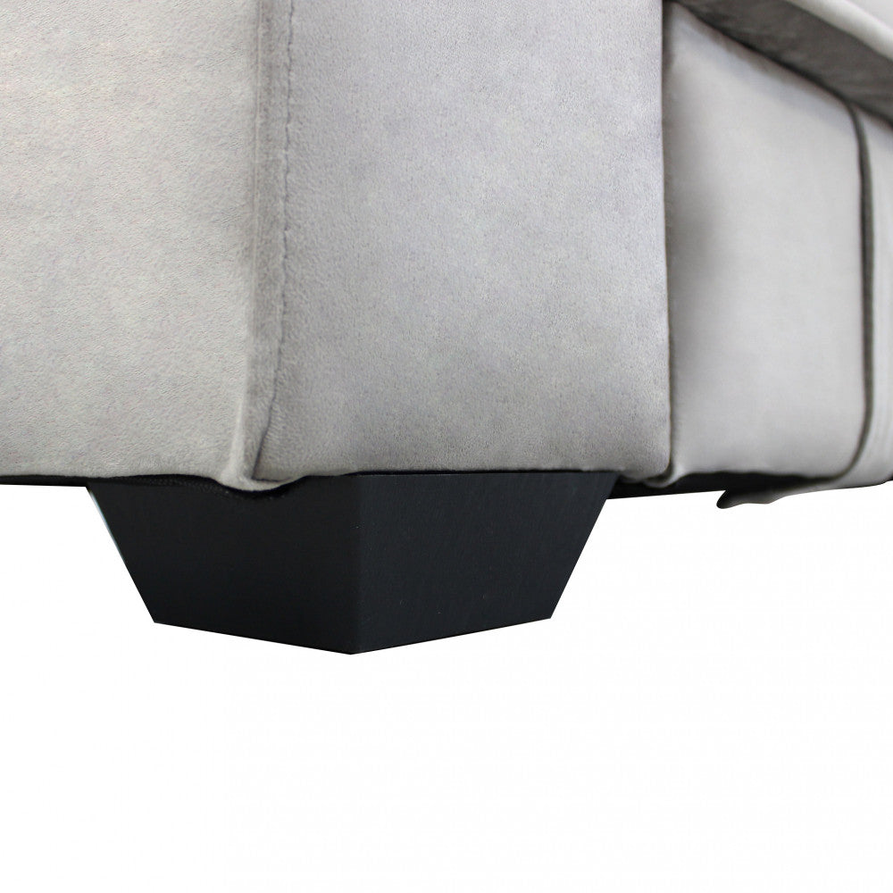 Dettaglio ravvicinato dei robusti piedini neri dal design geometrico e della raffinata texture del tessuto tortora del divano letto Darell.