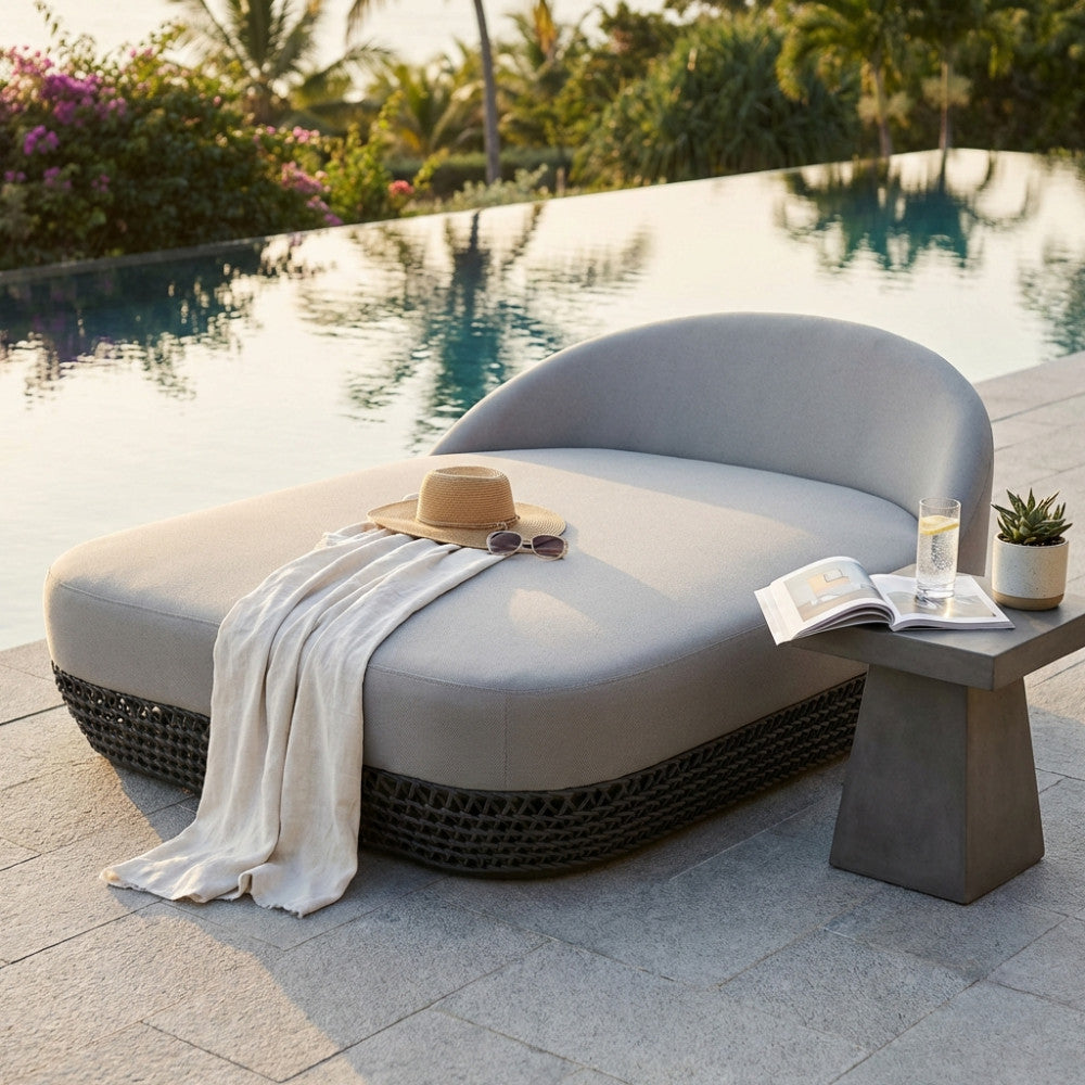 Divano letto Lafayette grigio a bordo piscina con cappello di paglia e asciugamano.
