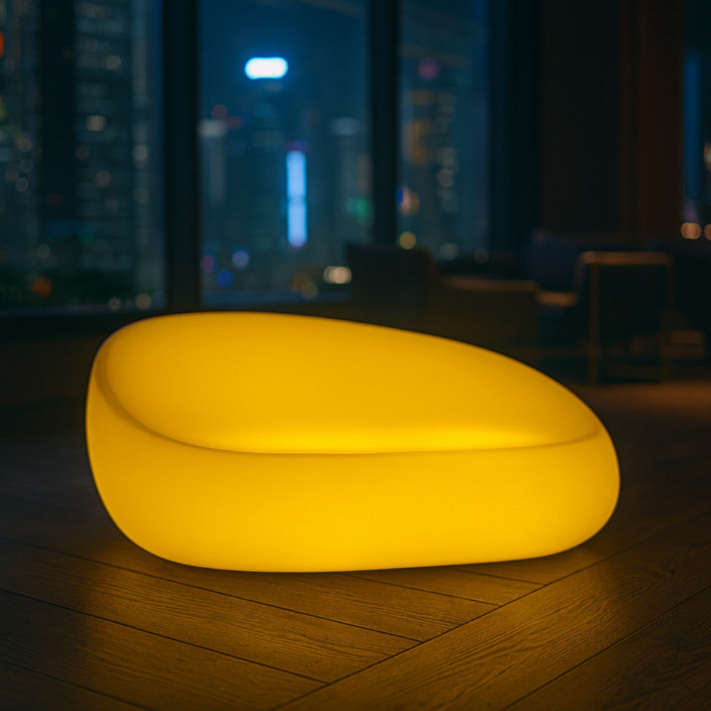 Divano luminoso giallo Lepus in un elegante soggiorno interno con pavimento in legno e vista notturna sulla città.