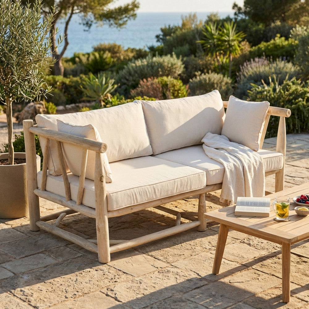 Divano Martinez con cuscini bianchi posizionato in un patio con vista mare.