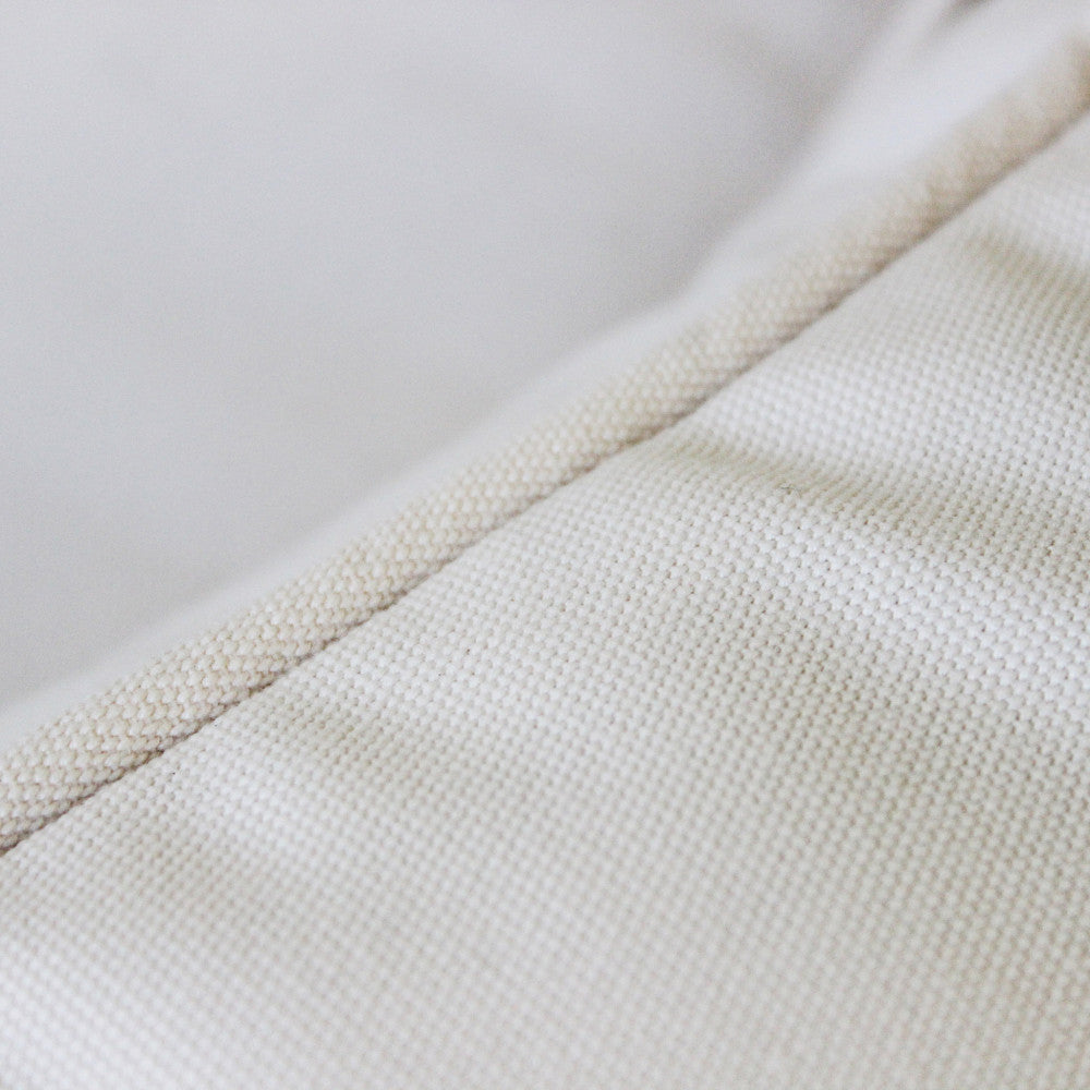 Dettaglio della trama del tessuto in poliestere color bianco tortora dei cuscini.