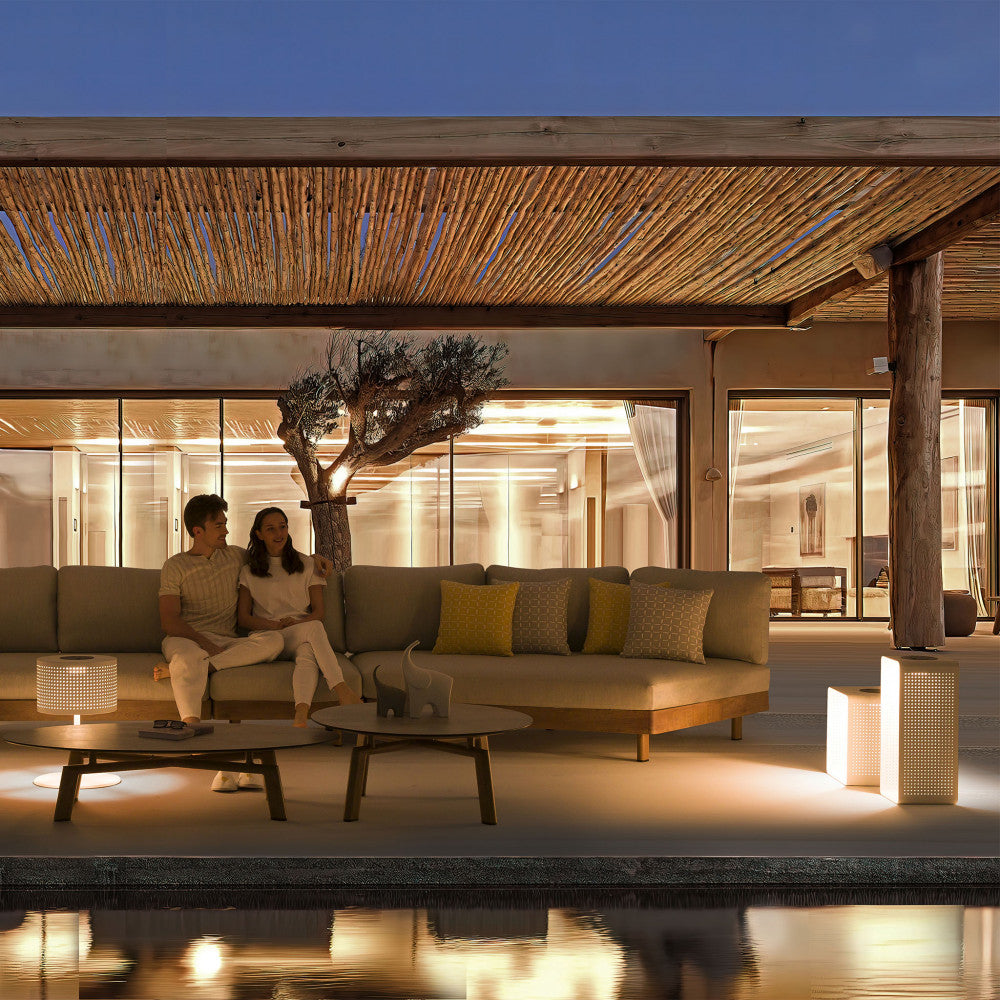 Ambientazione serale di lusso con il divano modulare illuminato su una terrazza.