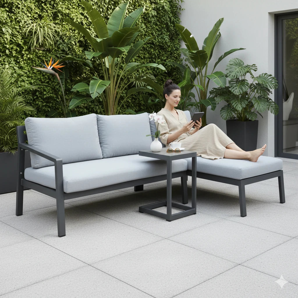 Divano Komodo da esterno in Alluminio Verniciato Antracite con pouf e tavolino laterale integrato, cuscini in Poliestere, ambientato in veranda