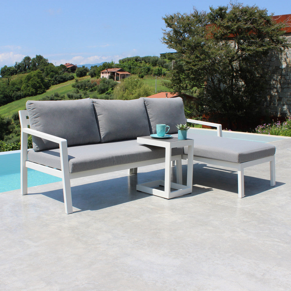 Divano con Tavolino Komodo in alluminio verniciato bianco in un ambiente esterno.