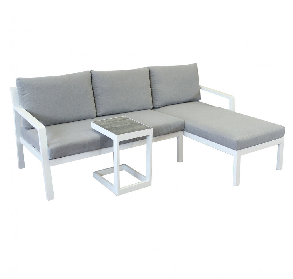 Divano con Tavolino Komodo in alluminio verniciato bianco in un ambiente esterno.