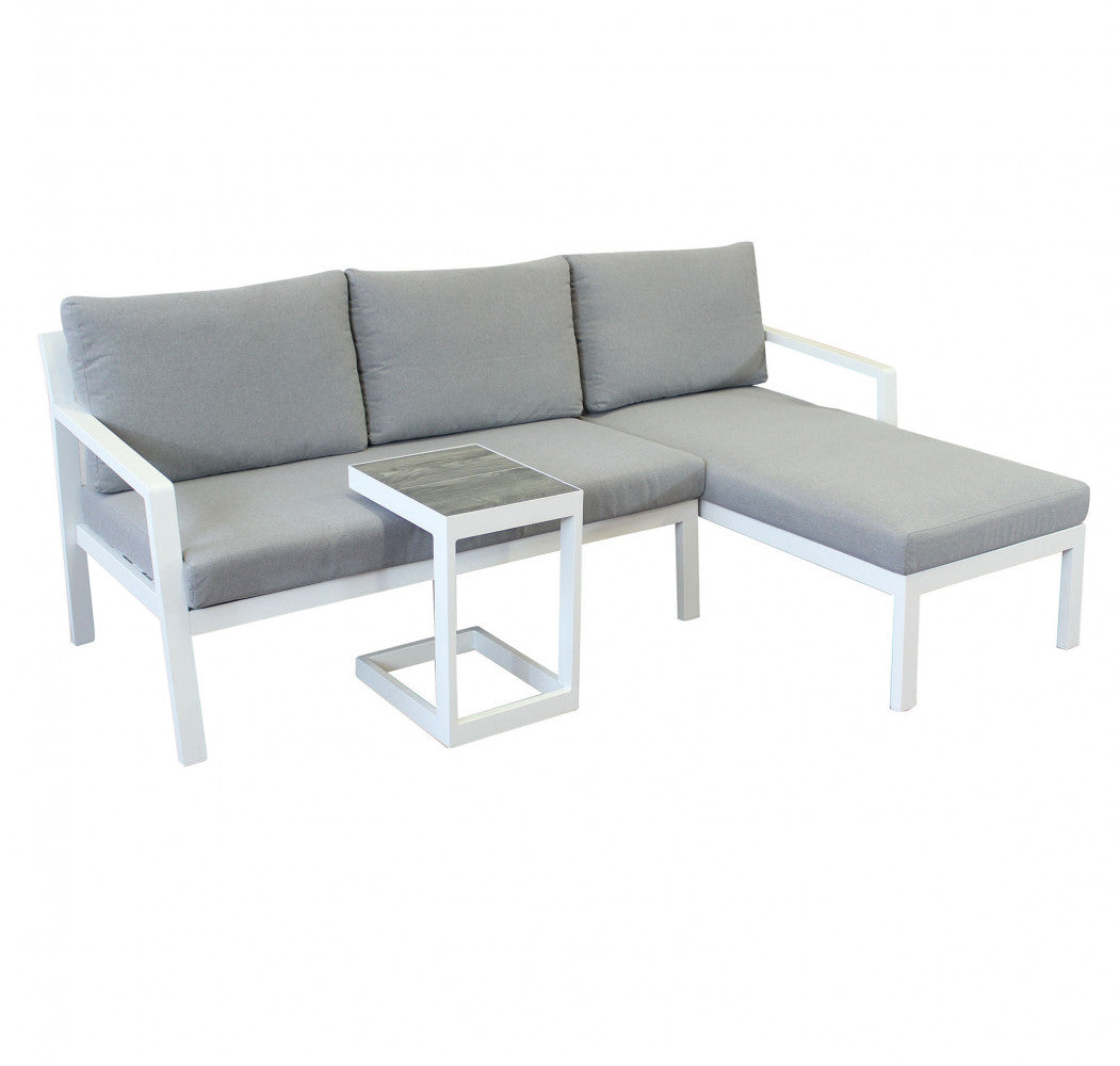 Divano con Tavolino Komodo in alluminio verniciato bianco in un ambiente esterno.