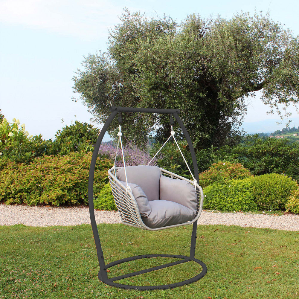 Dondolo moderno inserito in un contesto paesaggistico con prato e alberi.