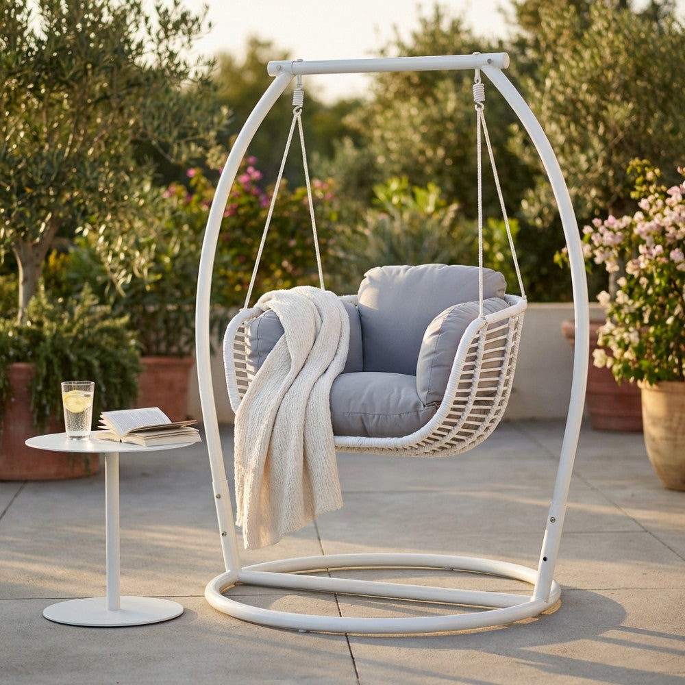 Seduta sospesa Glasgow con cuscini grigi e coperta chiara su una terrazza elegante.