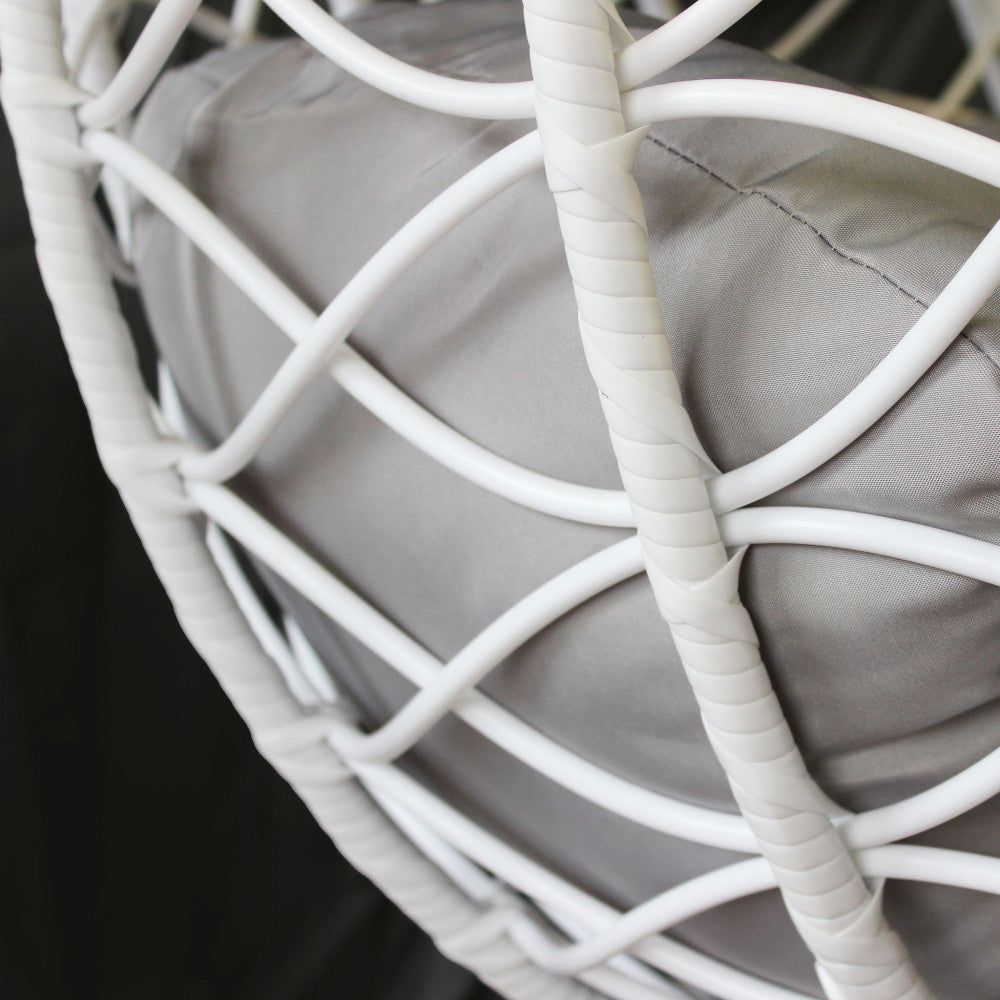 Dettaglio ravvicinato dell'intreccio in wicker bianco e del cuscino in poliestere grigio del dondolo Panarea.