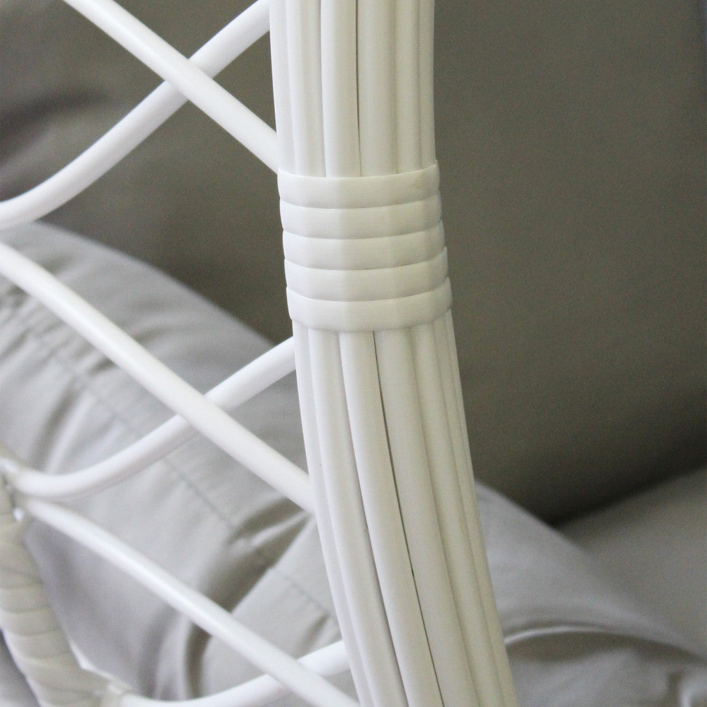 Particolare della struttura portante in metallo bianco e del rivestimento in wicker della poltrona sospesa.