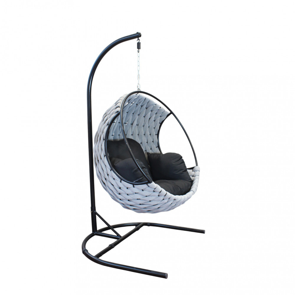 Vista di tre quarti in studio della poltrona sospesa Spargi con robusto supporto in alluminio nero.