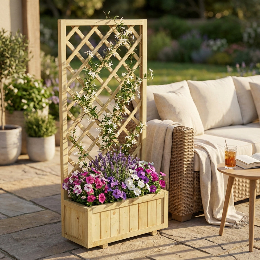 Fioriera in legno con griglia alta 180 cm, allestita con fiori colorati e gelsomino rampicante, posizionata accanto a un divano in rattan da esterno.