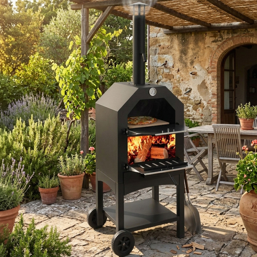 Forno per pizza Italy in metallo nero acceso in un giardino rustico con patio in pietra.