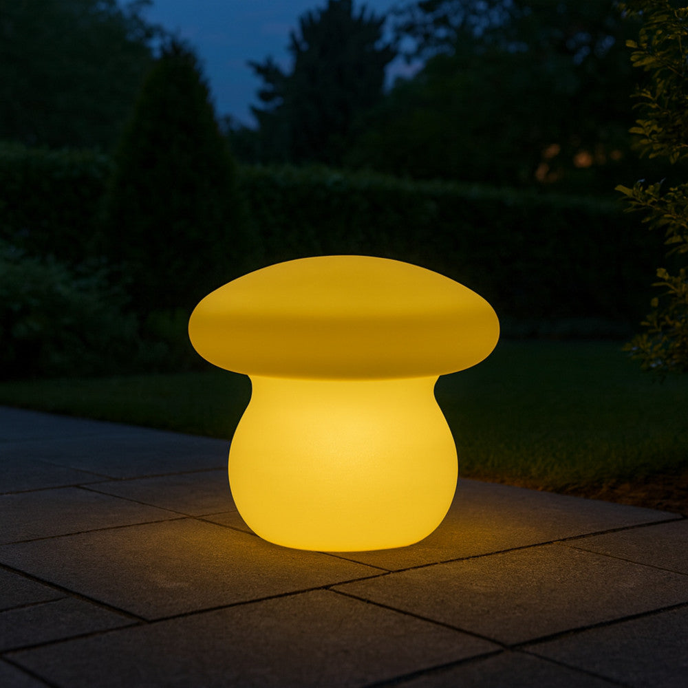 Lampada a fungo gialla che diffonde una luce calda su un sentiero lastricato in giardino durante la notte.