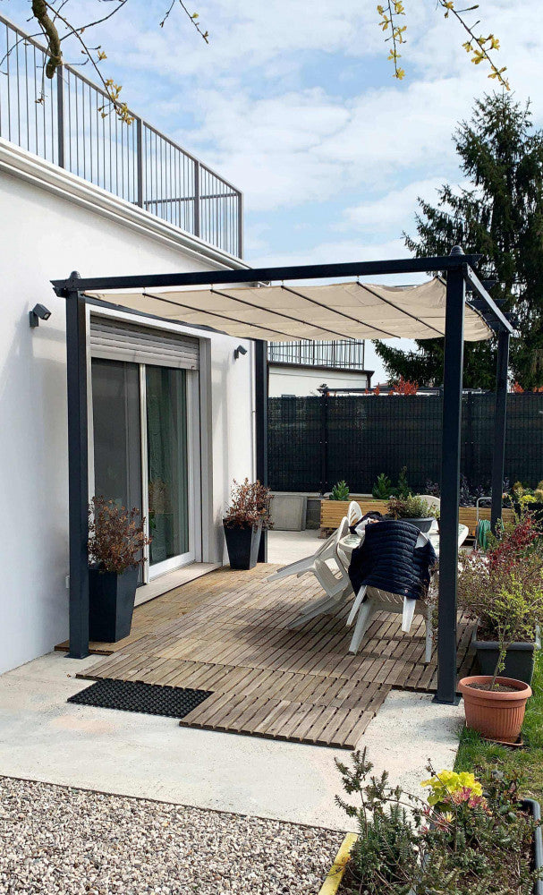 Gazebo Astoria installato su un deck in legno adiacente a una moderna abitazione bianca, creando un patio coperto.