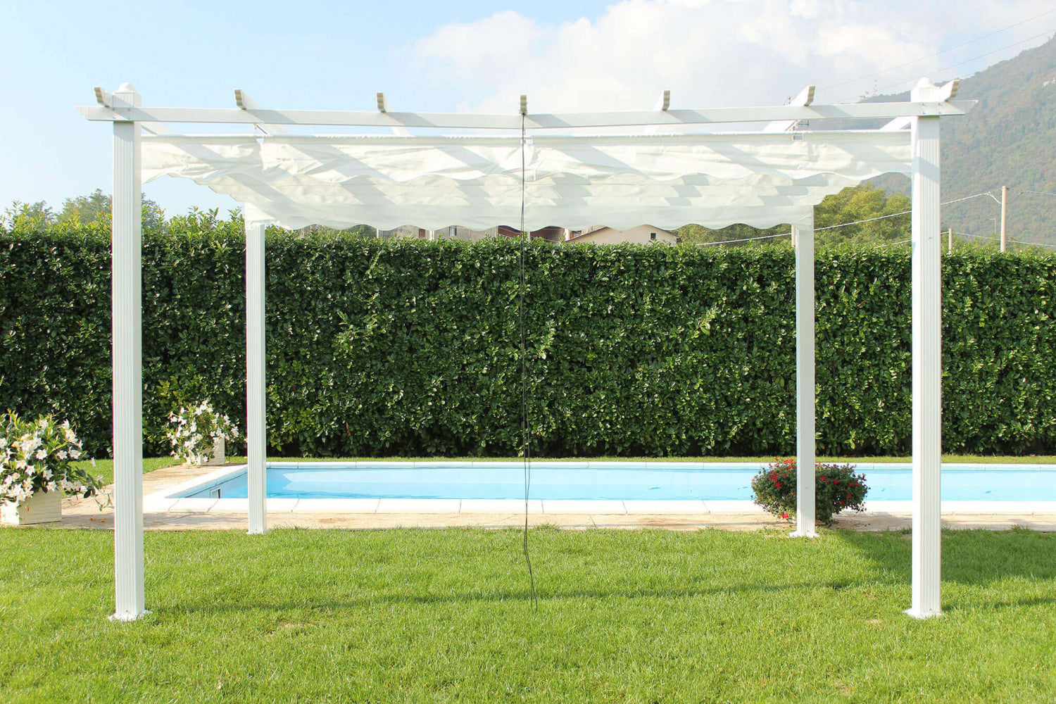 Gazebo Astoria posizionato a bordo piscina, con la copertura a onde in poliestere bianco.