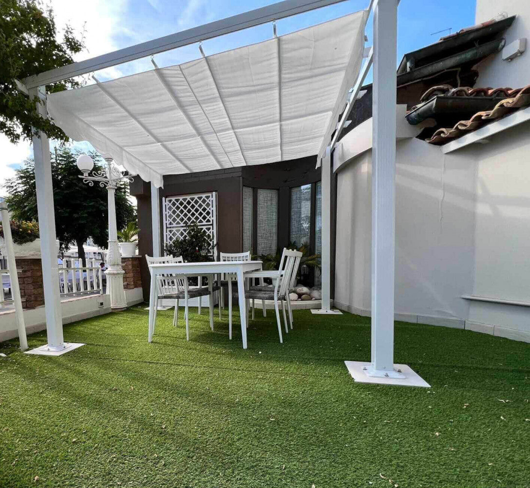 Gazebo Astoria installato su un prato sintetico in un contesto urbano con arredi bianchi.