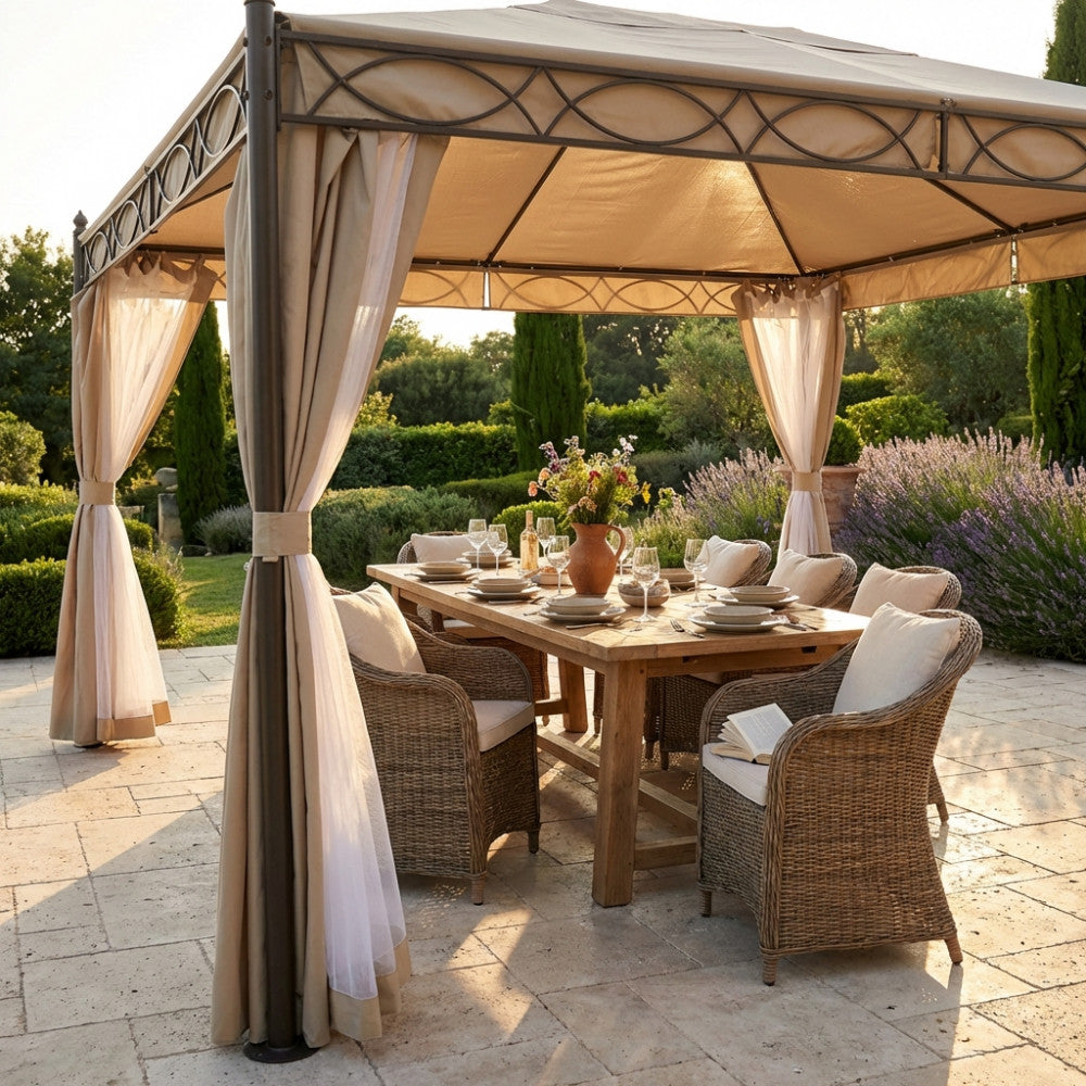 Dettaglio del Gazebo Karnak con tende in poliestere ecrù raccolte sui montanti in acciaio, che ombreggia un salotto da esterni in midollino.
